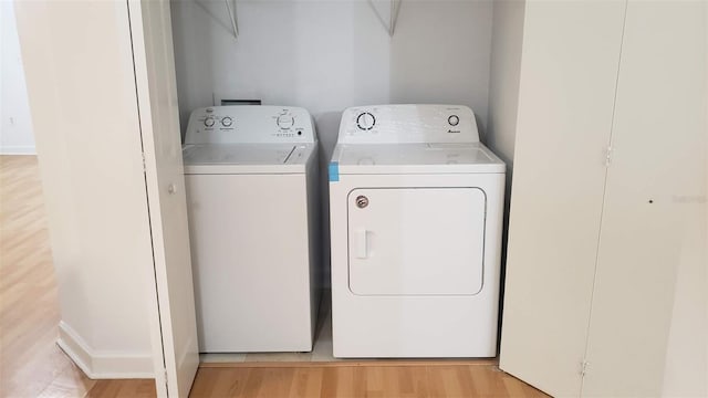 laundry room featuring washer and dryer and light hardwood / wood-style floors