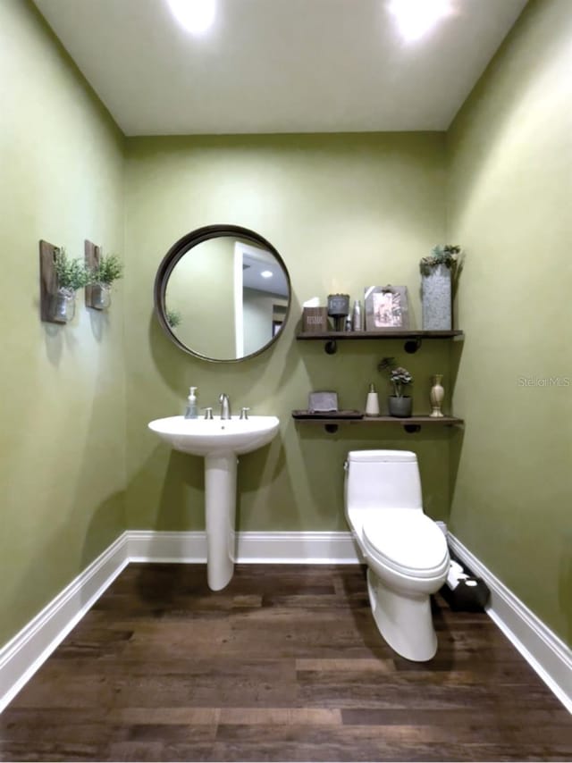 bathroom with hardwood / wood-style floors, sink, and toilet