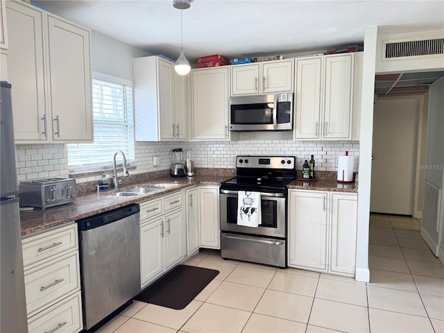 kitchen featuring white cabinets, appliances with stainless steel finishes, sink, and light tile patterned floors