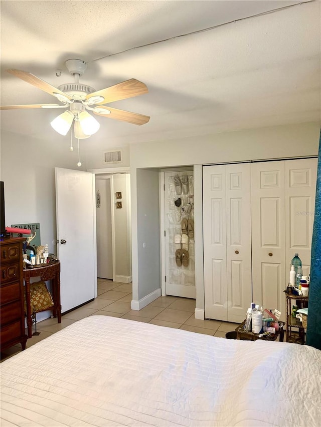 tiled bedroom featuring ceiling fan