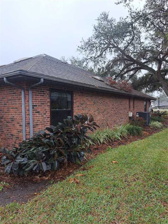 view of property exterior with a yard and central AC