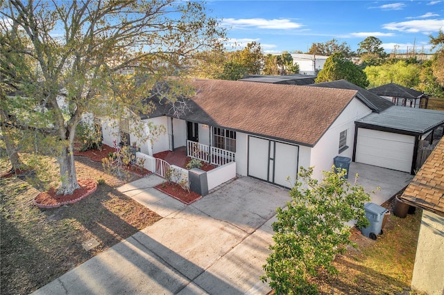 view of front of house with an attached garage, driveway, a shingled roof, and stucco siding