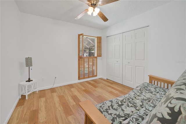 sitting room with a ceiling fan, a textured ceiling, baseboards, and wood finished floors