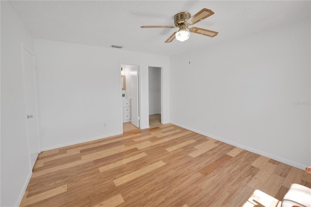 empty room featuring light wood-type flooring, visible vents, and baseboards