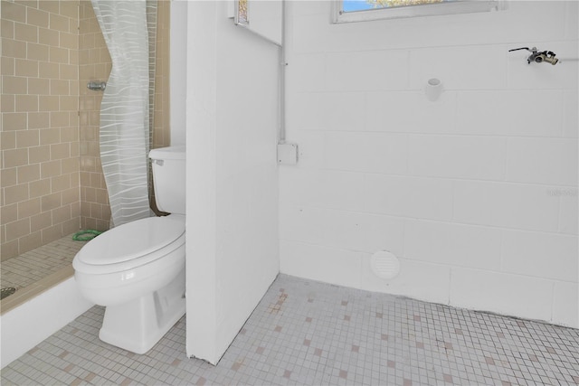 full bathroom featuring toilet, a shower stall, and tile patterned floors