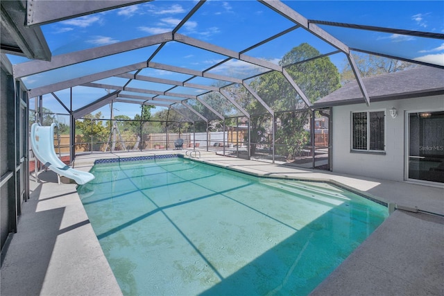 view of swimming pool with a fenced in pool, a water slide, a patio, and a lanai