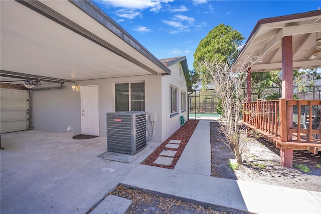 view of side of property featuring central AC unit and stucco siding