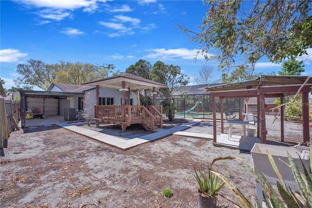 back of property featuring a patio, central air condition unit, glass enclosure, fence, and a garage