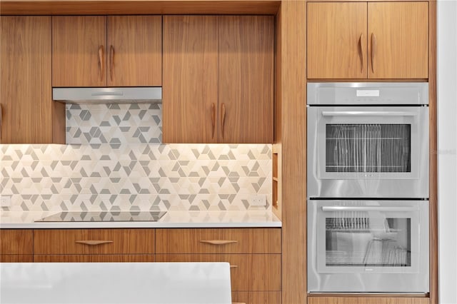 kitchen with black electric stovetop, backsplash, and double oven