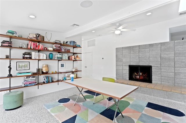 office area with a brick fireplace and ceiling fan