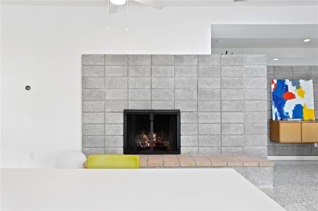 details featuring ceiling fan and a brick fireplace