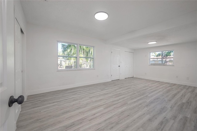 unfurnished bedroom with a textured ceiling and light wood-type flooring