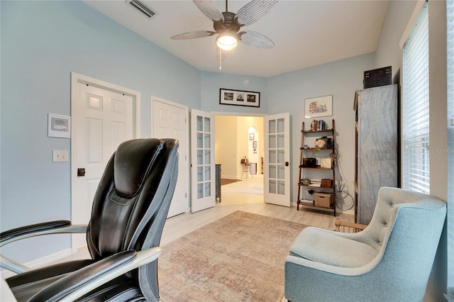 office with light hardwood / wood-style flooring, ceiling fan, and french doors