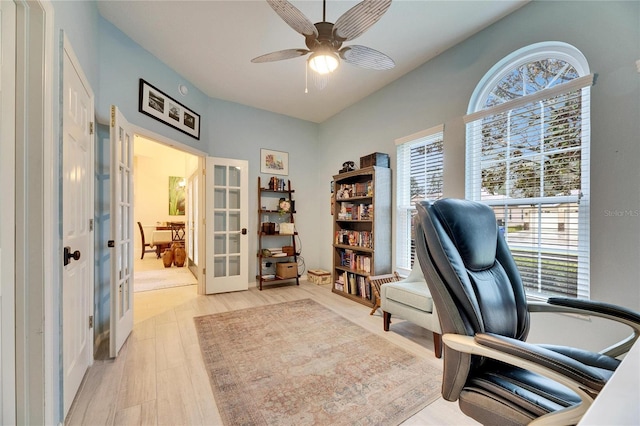 office space with light wood-type flooring, ceiling fan, french doors, and a healthy amount of sunlight