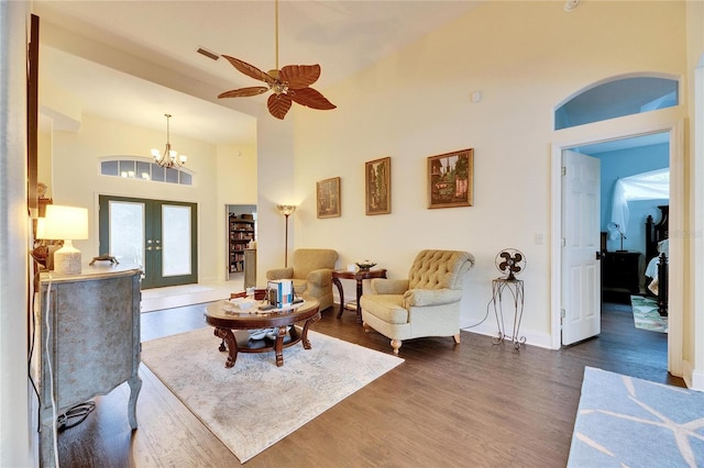 living room featuring ceiling fan with notable chandelier, dark hardwood / wood-style floors, high vaulted ceiling, and french doors