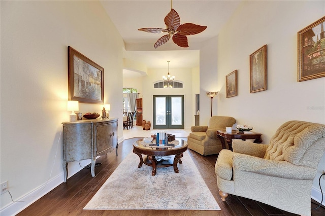 living room with ceiling fan with notable chandelier, french doors, and dark hardwood / wood-style flooring