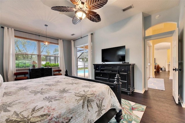 bedroom with ceiling fan, dark wood-type flooring, and access to outside