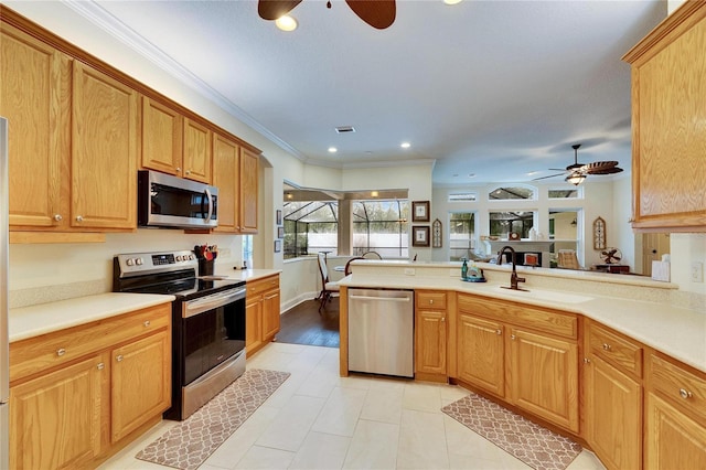 kitchen with ceiling fan, kitchen peninsula, crown molding, and stainless steel appliances