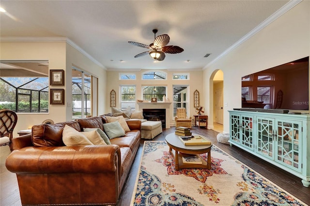 living room featuring ceiling fan, crown molding, and dark wood-type flooring