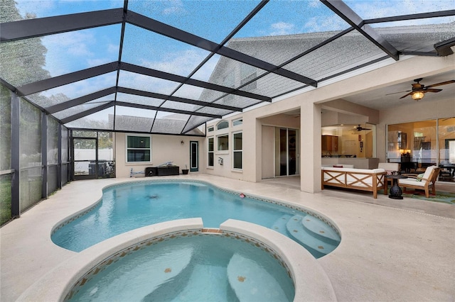 view of pool featuring an outdoor living space, glass enclosure, ceiling fan, an in ground hot tub, and a patio area