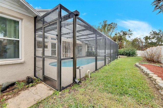 view of swimming pool with glass enclosure and a lawn