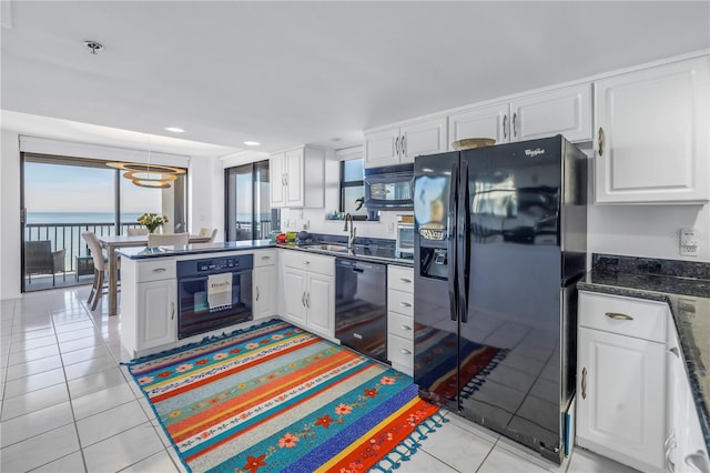 kitchen featuring sink, black appliances, white cabinets, and a water view