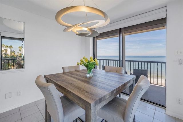 dining space with a water view, light tile patterned floors, and a wealth of natural light