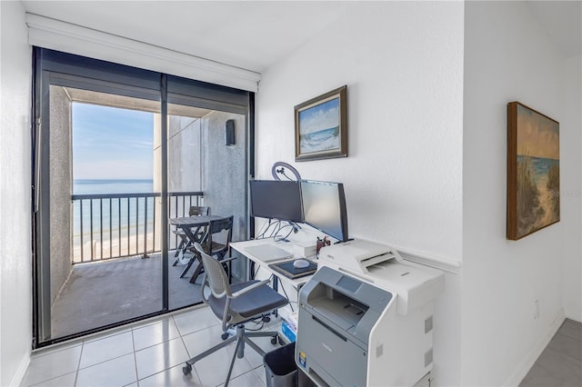 office space with a wall of windows and light tile patterned floors