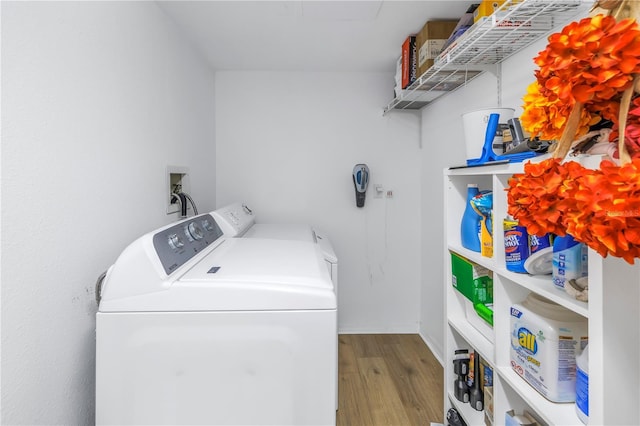 laundry area with separate washer and dryer and light hardwood / wood-style flooring