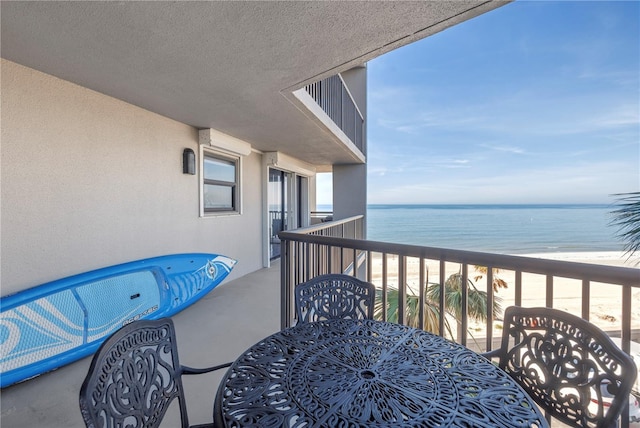 balcony featuring a water view and a beach view