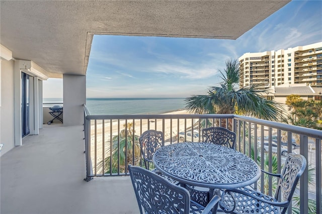 balcony featuring a water view and a view of the beach