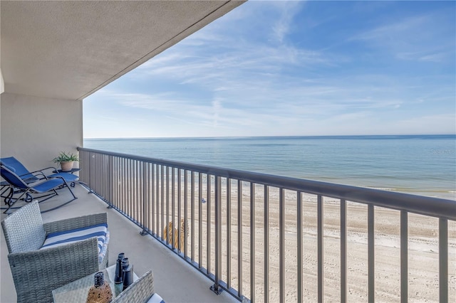 balcony featuring a beach view and a water view