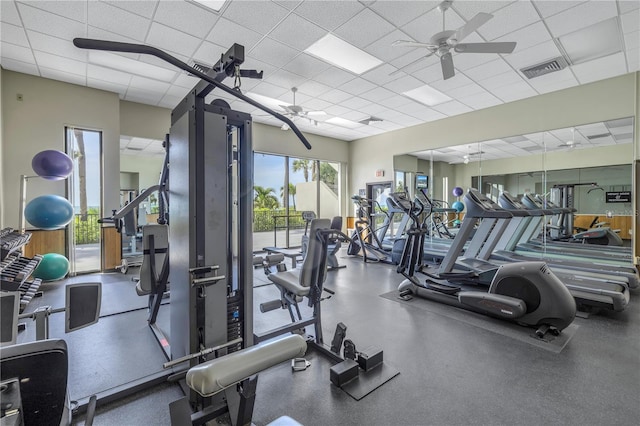 gym with ceiling fan and a drop ceiling