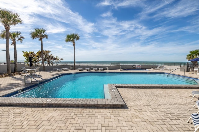 view of pool featuring a patio and a water view