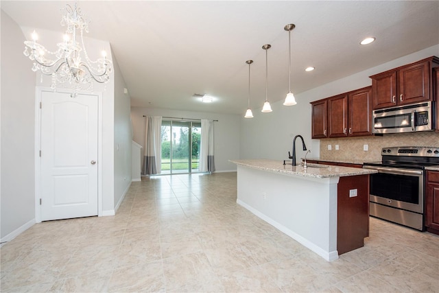 kitchen with decorative light fixtures, an island with sink, sink, stainless steel appliances, and light stone countertops