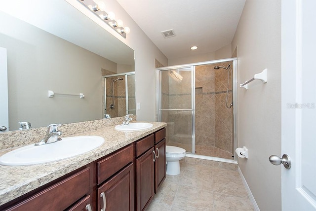 bathroom featuring vanity, toilet, and a shower with shower door