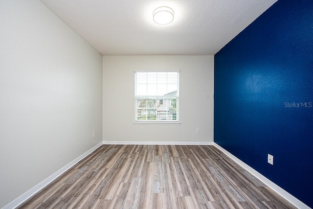 spare room with hardwood / wood-style floors and a textured ceiling