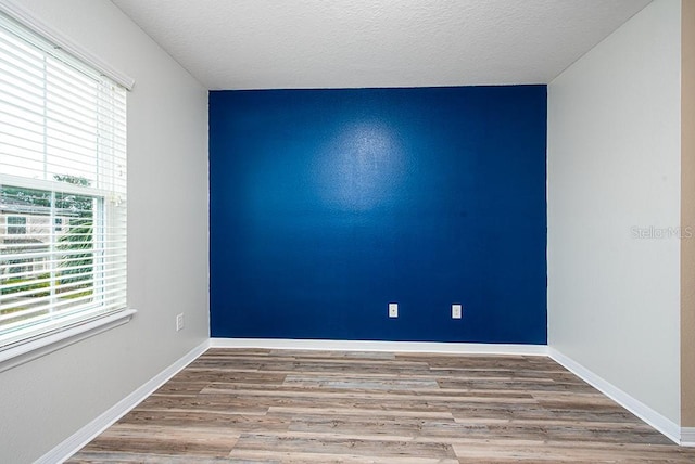 spare room with hardwood / wood-style floors and a textured ceiling