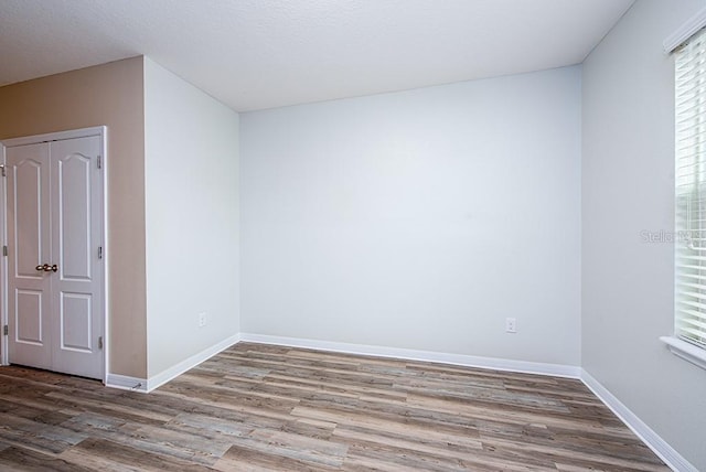 unfurnished room with wood-type flooring