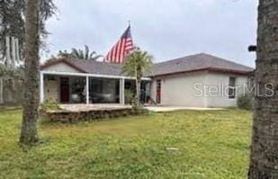 rear view of property with a sunroom and a yard