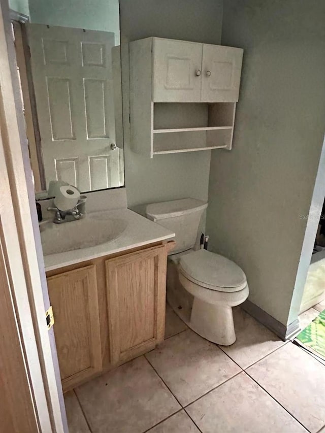 bathroom with vanity, toilet, and tile patterned flooring