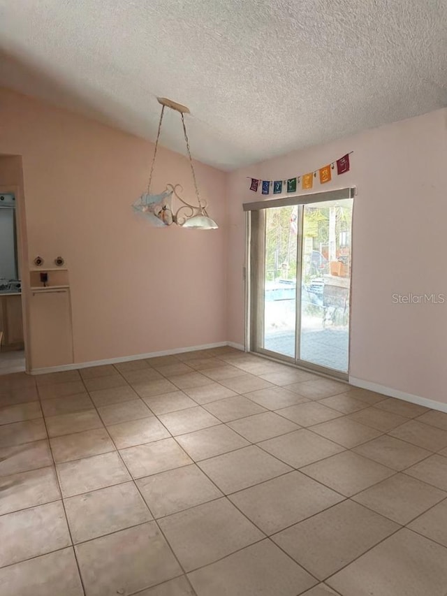 tiled empty room with lofted ceiling and a textured ceiling