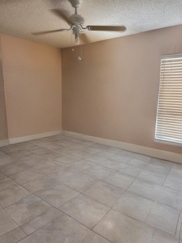 empty room featuring ceiling fan and a textured ceiling