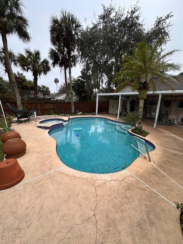 view of swimming pool featuring an in ground hot tub and a patio