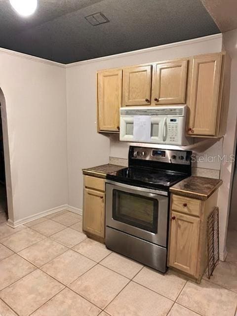 kitchen with light tile patterned floors, stainless steel range with electric cooktop, a textured ceiling, and light brown cabinets