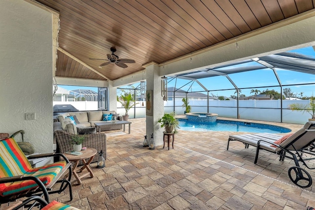 view of patio / terrace with an in ground hot tub, ceiling fan, a lanai, and outdoor lounge area