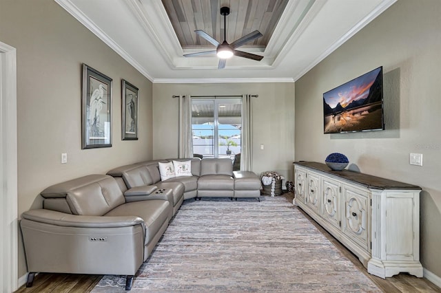 living room featuring ceiling fan, a raised ceiling, ornamental molding, and light hardwood / wood-style floors