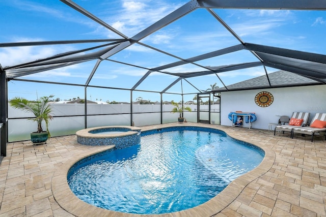 view of pool featuring glass enclosure, an in ground hot tub, and a patio area