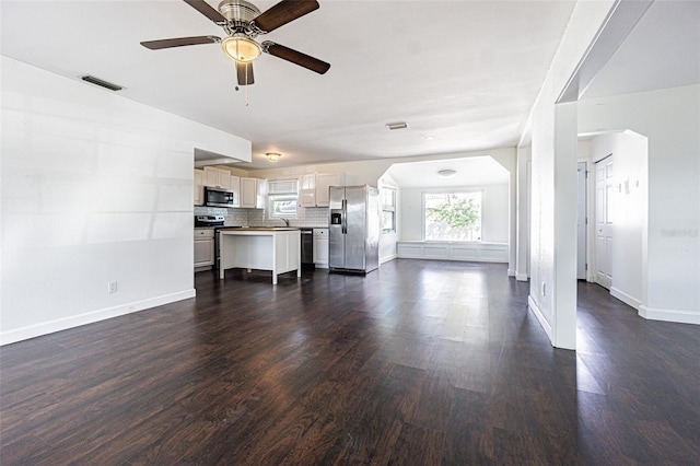 unfurnished living room with dark hardwood / wood-style flooring, sink, and ceiling fan