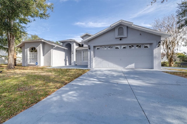 ranch-style home featuring a garage and a front lawn